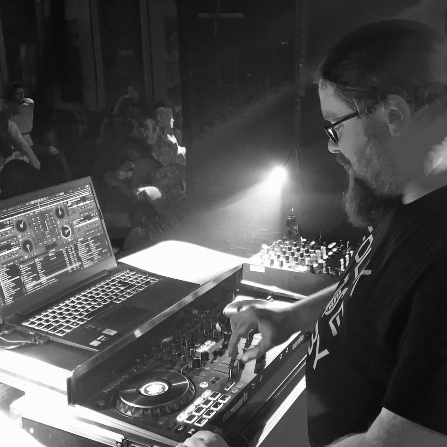 DJ an einem Mischpult, konzentriert bei der Musikproduktion im Club.